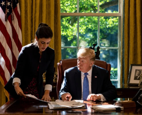 Madeleine Westerhout reviewing documents with President Trump in the Oval Office