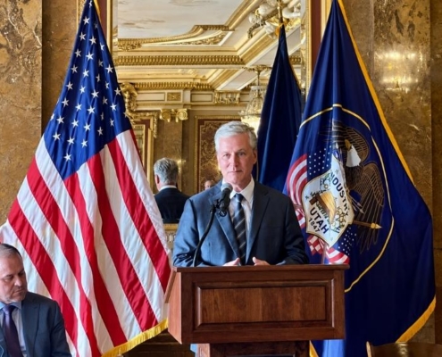 Global risk advisory firm speaker addressing U.S. policy with American and Utah flags