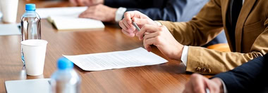 Business professionals reviewing documents and evaluating the implications of AI policy decisions.