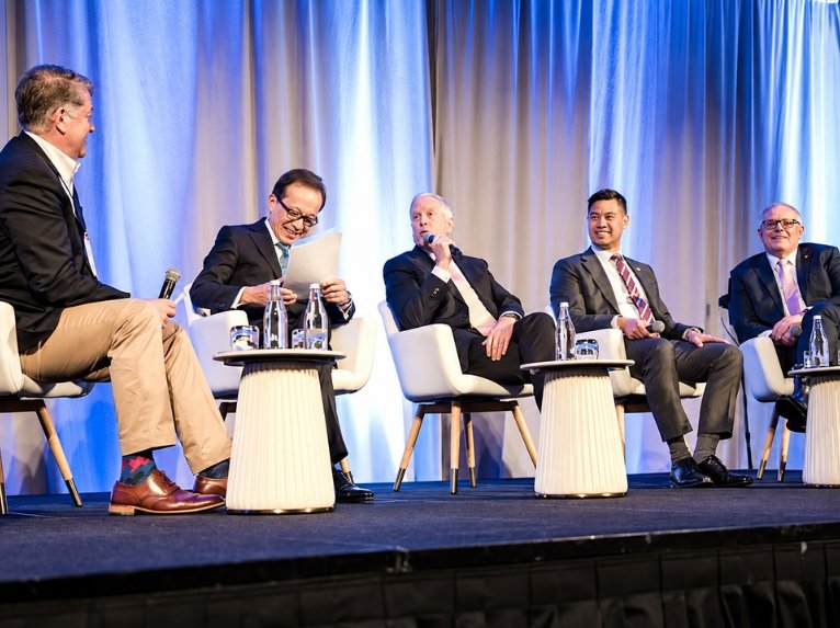 Panelists discussing international trade and policy during a business conference.