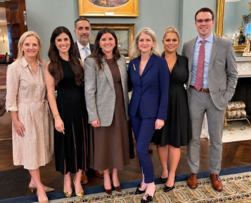 Team of public affairs and strategic advisory professionals posing together in a formal office.